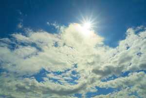 The sun peeking out from the edge of a cloud The sun peeking out from the edge of a cloud