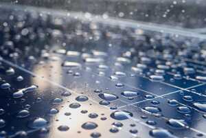 Extreme close up of raindrops on a solar panel