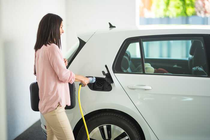 woman charging her electric car